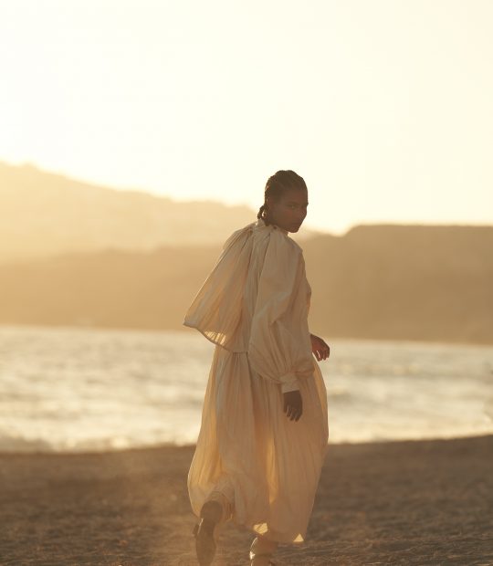 Model running on the beach wearing Jil Sander